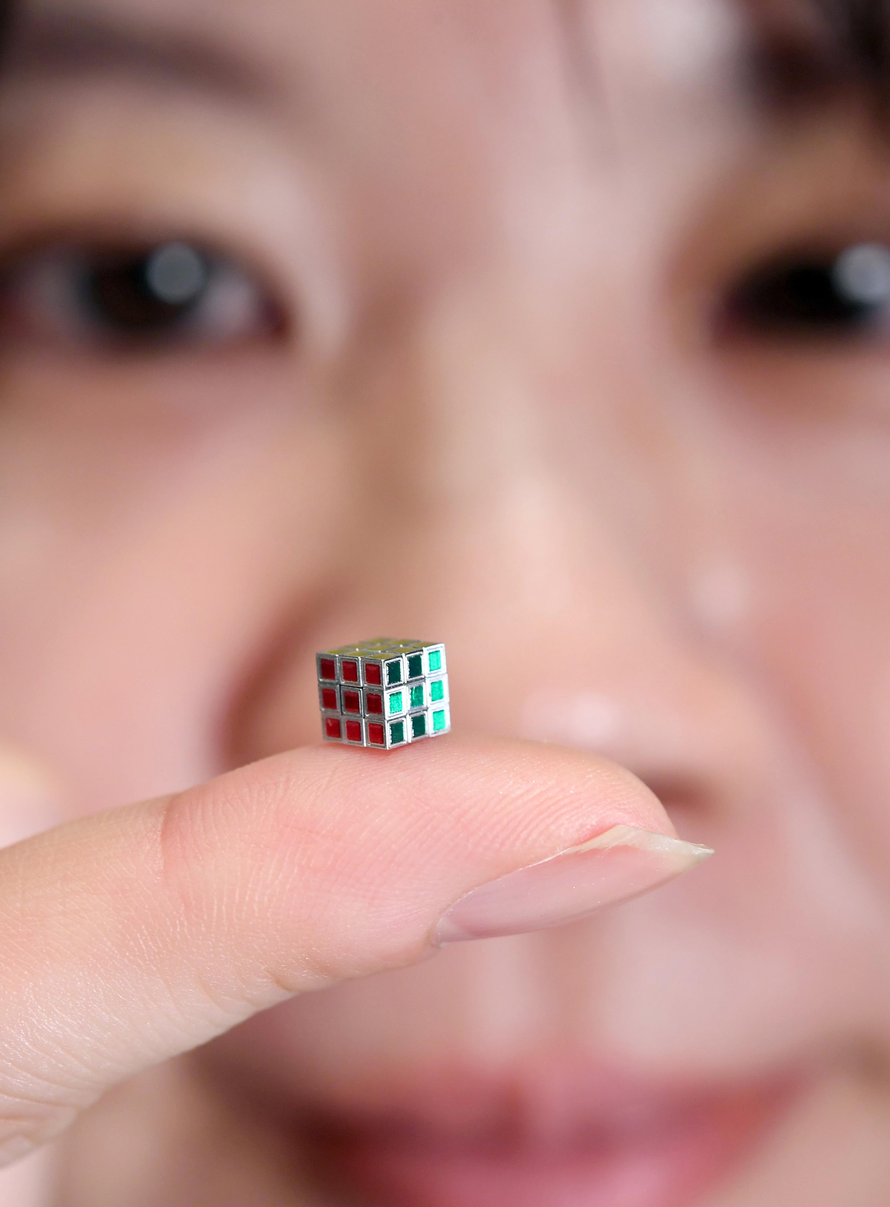 一辺約5ミリ「究極最小ルービックキューブ」を報道陣に公開 77万7777円